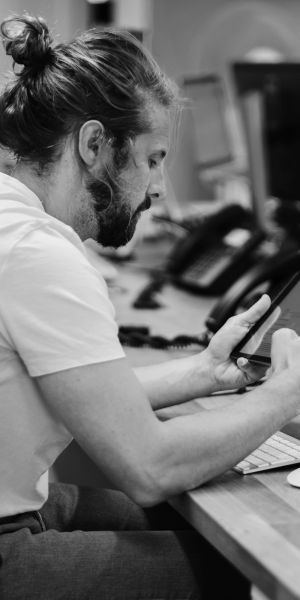 Man sitting at desk in an office looking into an iPad